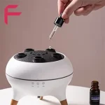 ریختن قطره اسانس و روغن معطر داخل مخزن دستگاه آروماتراپی و رطوبت ساز V80